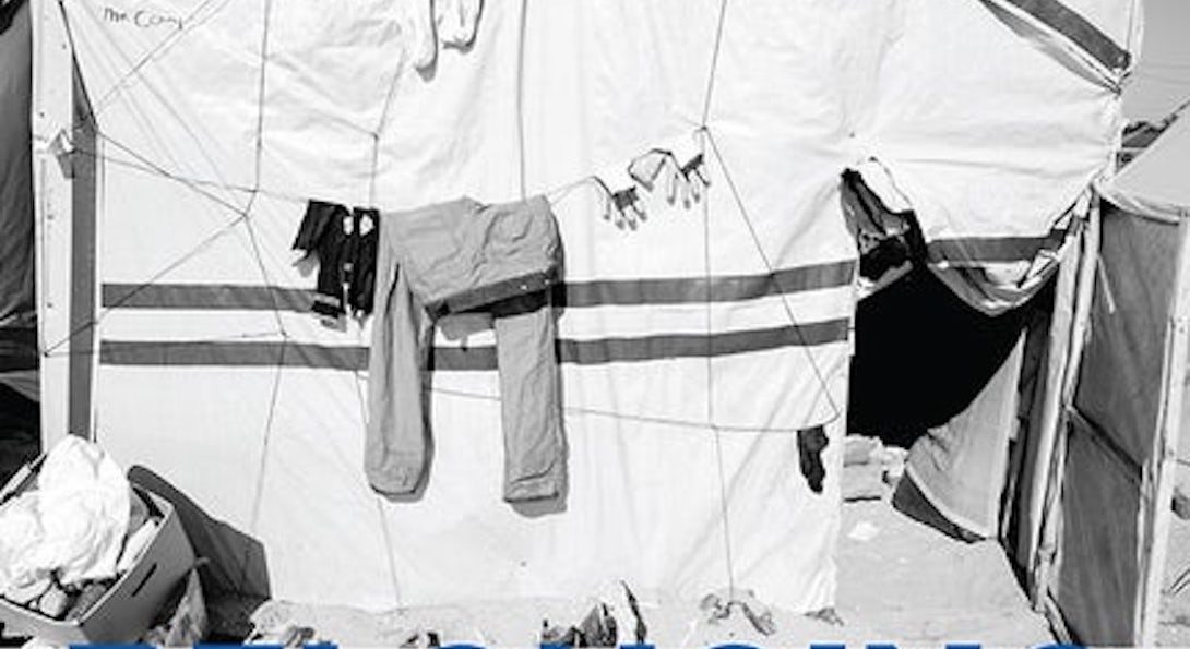 Blue and White book cover with a black and white imagery of clothes hanging on a cloth line in front of a tent